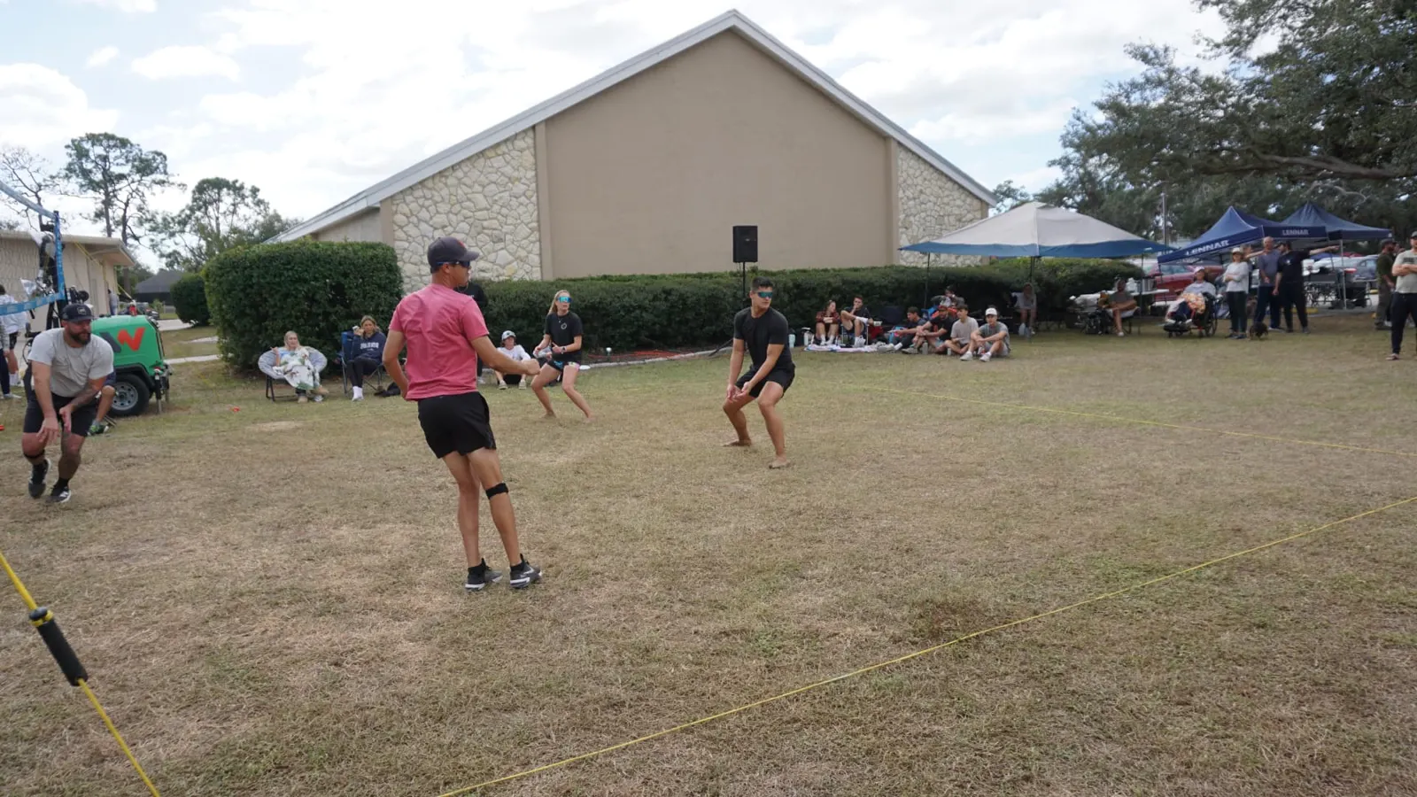 Players ready in position with spectators watching beside the church