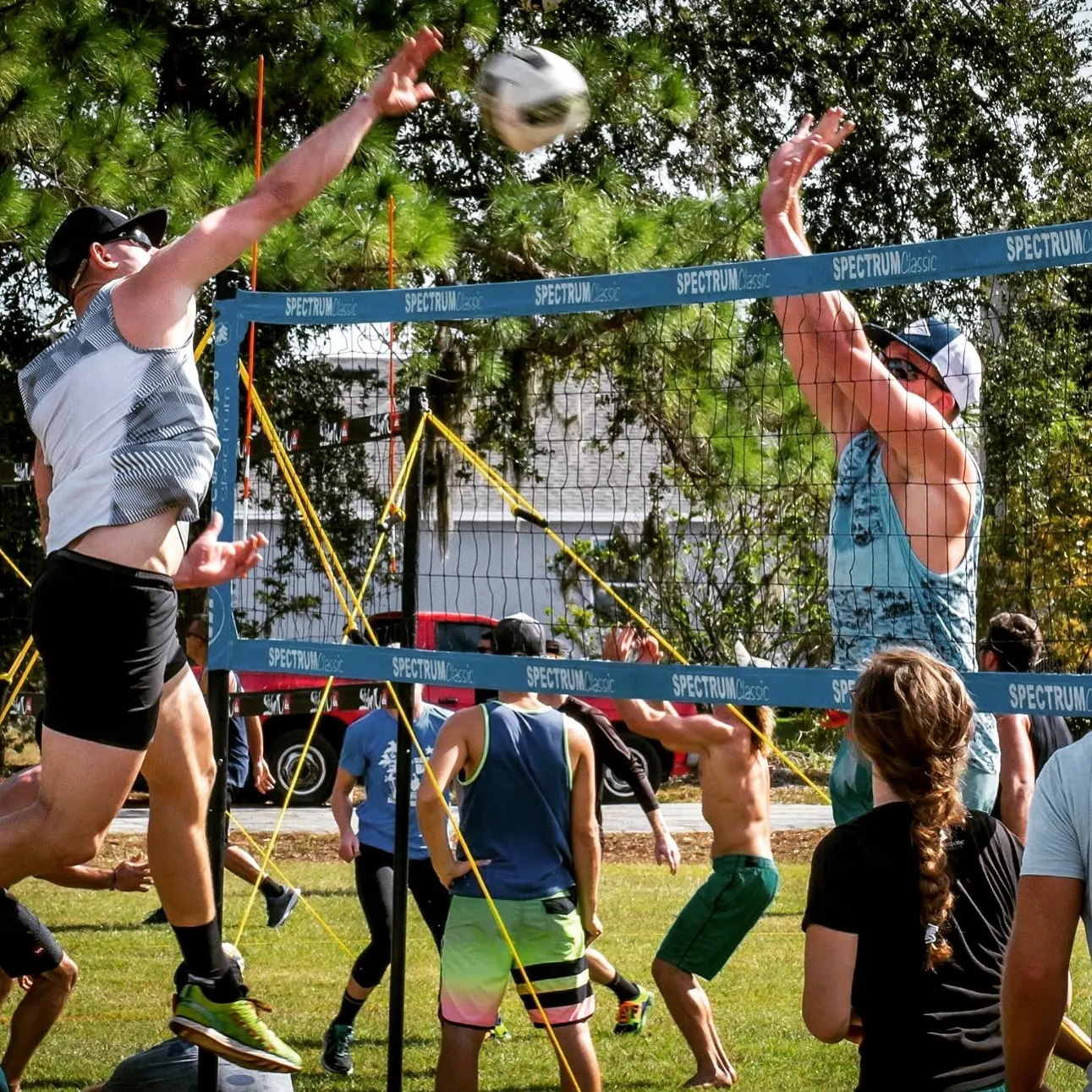 A spike and block at the grass volleyball net