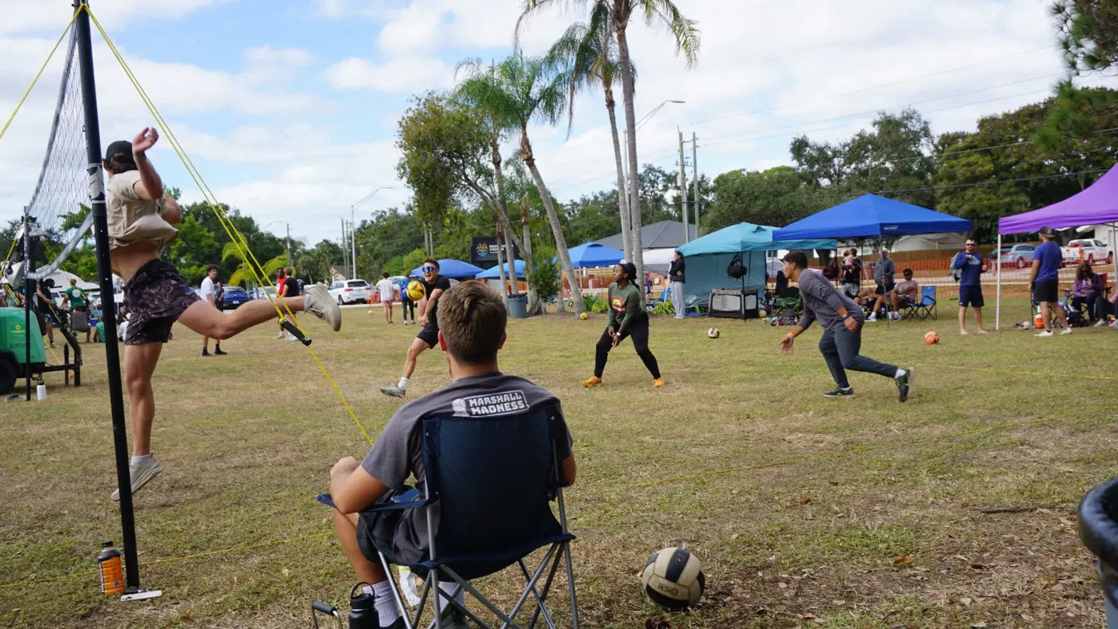 A player kicks high to save the ball while teammates react